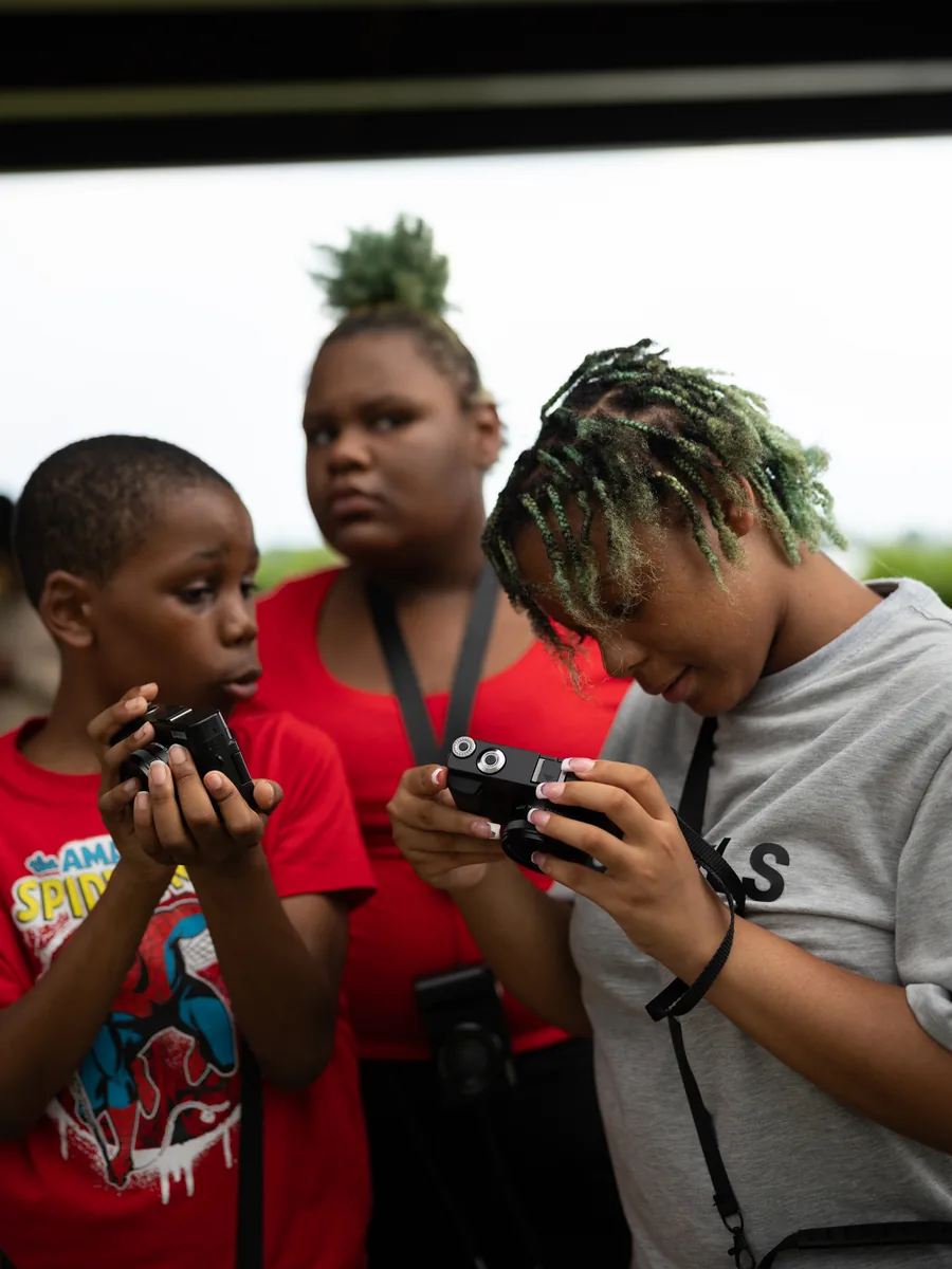 Young people learning photography during a Crowns multimedia experience.